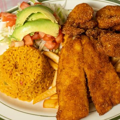 Breaded seafood platter served with rice, salad, avocado slices, and French fries.