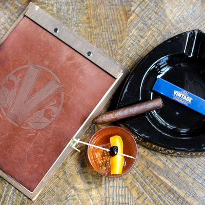 Cigar box, ashtray, cigar, matches and Sazerac