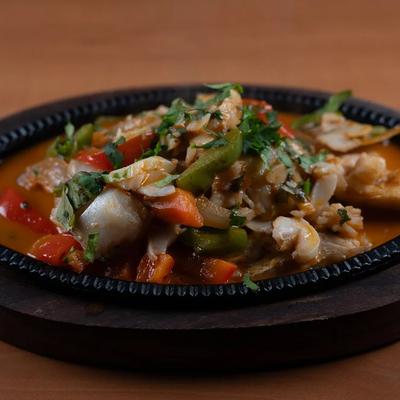 Sizzling chicken platter with sautéed vegetables, served on a cast-iron skillet.