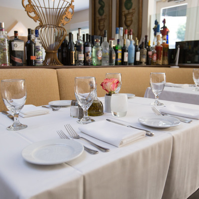 Interior, fully set banquette tables.