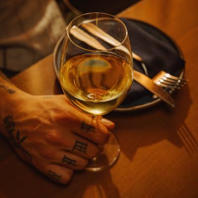 Glass of white wine in a hand.
