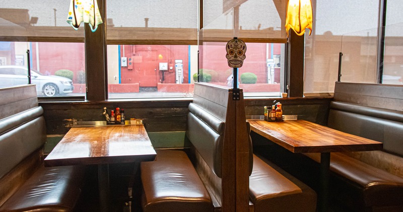 Two restaurant booths with wooden tables and brown seats