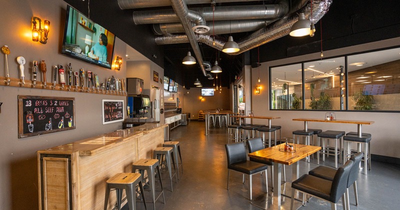 Interior, seating area, wooden top tables with condiments, beer tap station