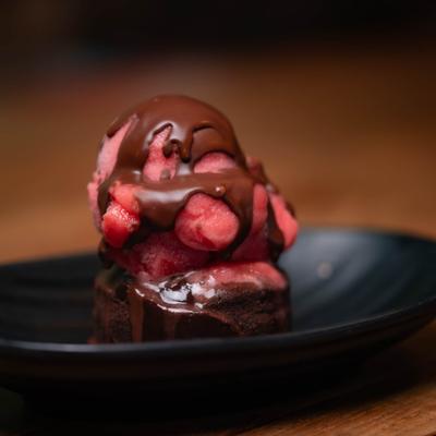 Lava cake topped with berry ice cream and melted chocolate.