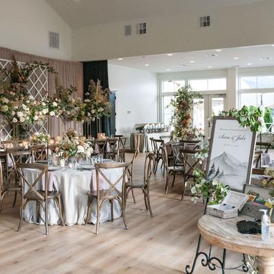 Wedding reception with round tables draped in silver linens, adorned with lush floral arrangements