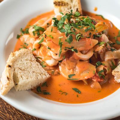 Sea food with vegetables and sauce, bread on the side