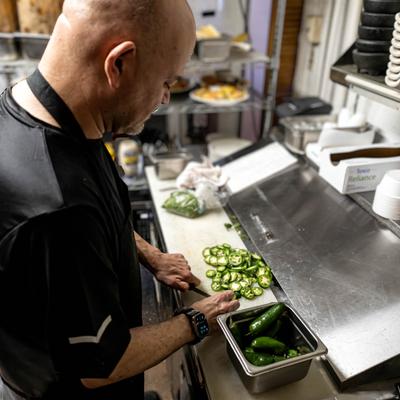 Cook chopping jalapenos.