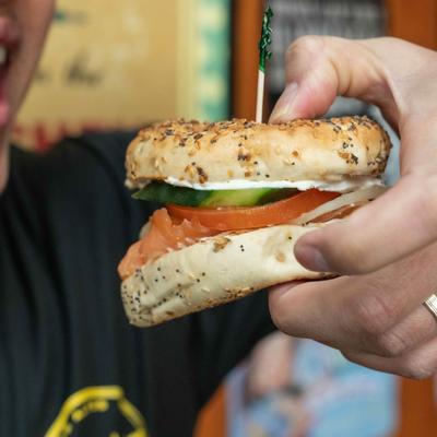 Employee's hand holding lox bagel