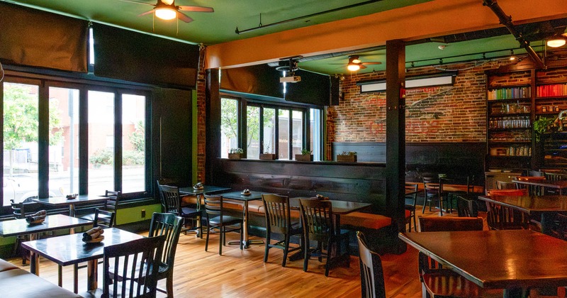 Interior, dark wood furniture, exposed brick wall with a mural, and large windows