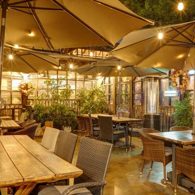 Outdoor seating under large umbrellas and string lights.