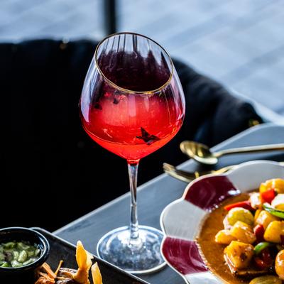 Pear delight cocktail beside plated food.