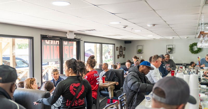 Interior, people seated at the bar and tables, staff serving