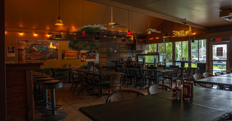 Interior of a casual dining restaurant featuring wooden tables and black chairs