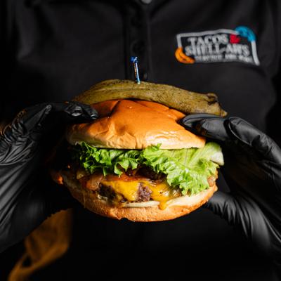 Cheeseburger with melted cheese, lettuce, and a green chile on top.