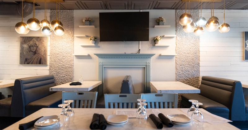 Interior, booths, tables and chairs, a wall TV screen