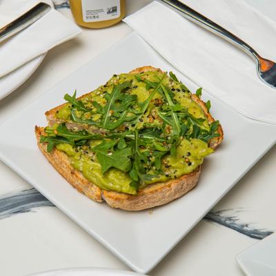 Avocado toast topped with arugula.