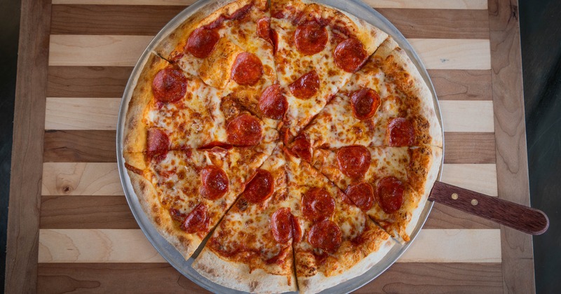 Pepperoni pizza on served a metal tray