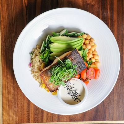 Woodfired salmon, with quinoa, chickpeas, tomatoes, cucumber, avocado, herbs, and sauce