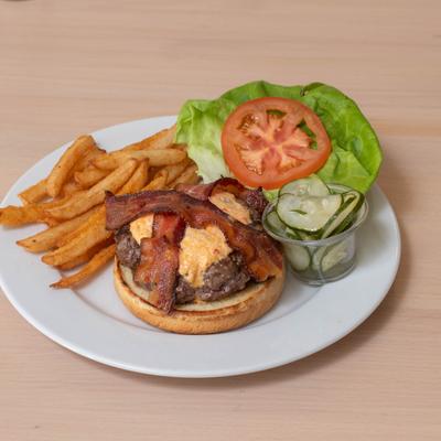 Burger with pimento cheese, bacon, lettuce, tomato, and a side of fries.