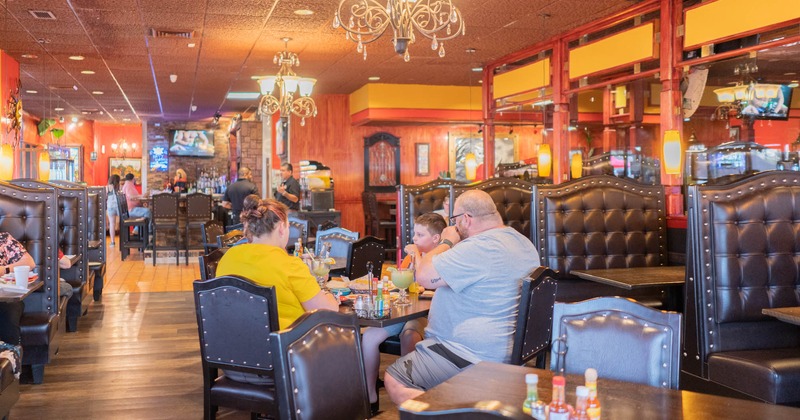 Interior, guests sitting at the table and enjoying their food and drinks