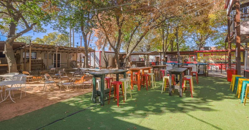Patio, colorful metal bar stools, tables, and a fire pit