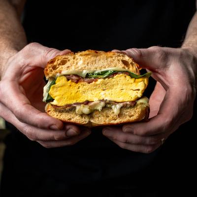 Hands holding the deluxe sandwich.