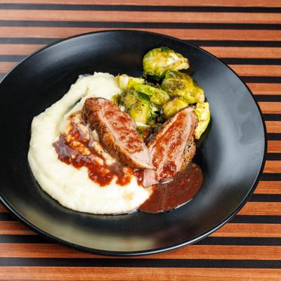 Duck meat in raspberry sauce, with mashed potatoes and crispy brussels sprouts.