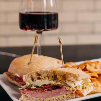 Big G Sandwich served with chips and red wine.