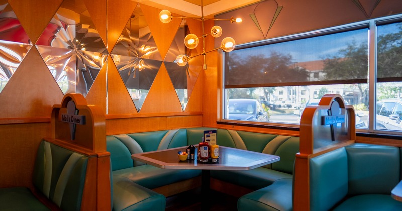 Interior, dining area, large corner searing booth, windows with blinds, mirror decoration