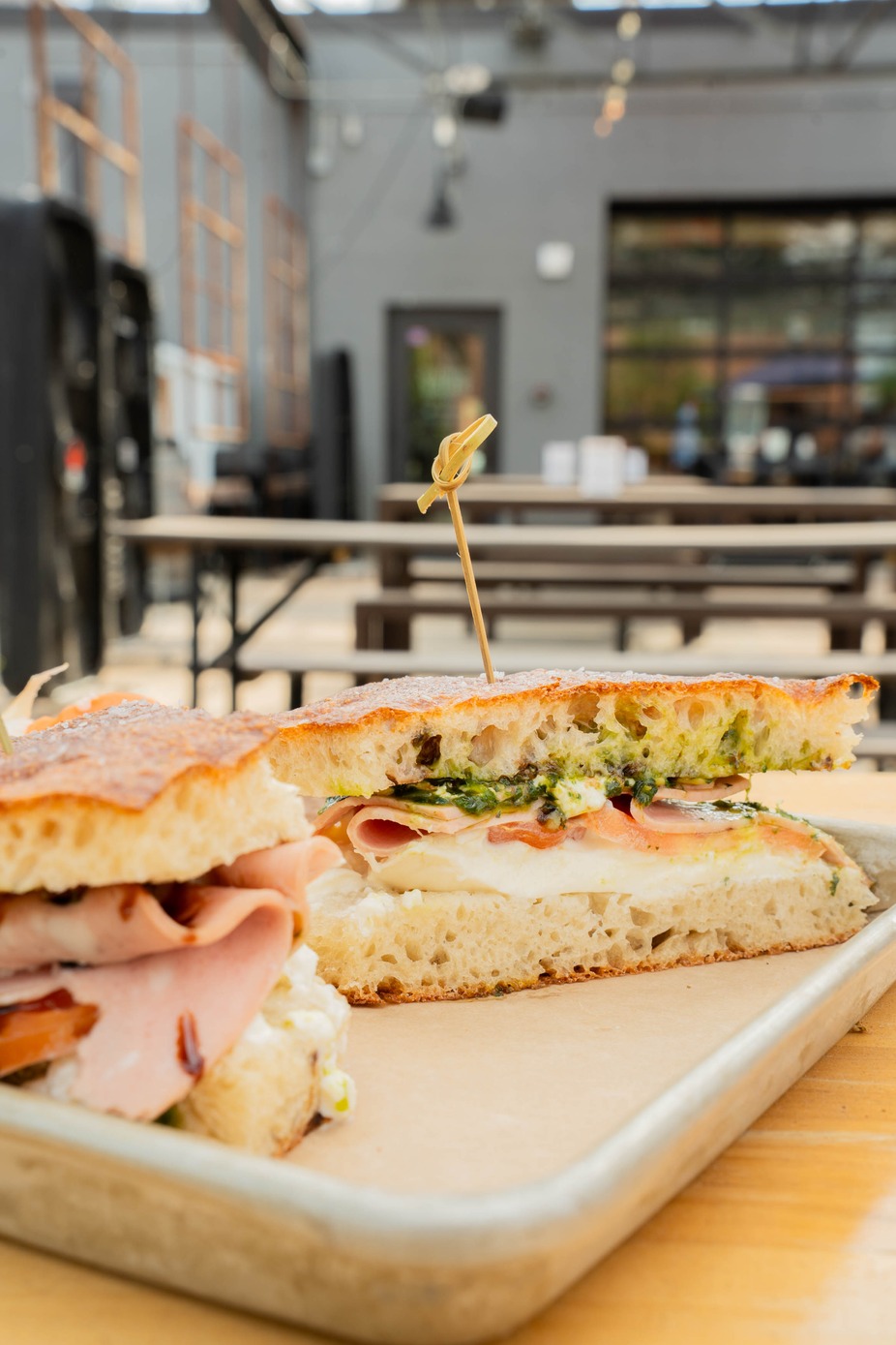 The Paradiso - premium sliced mortadella, creamy burrata, and sliced tomatoes topped with pistachio pesto then finished with a sweet balsamic reduction on schiacciata bread