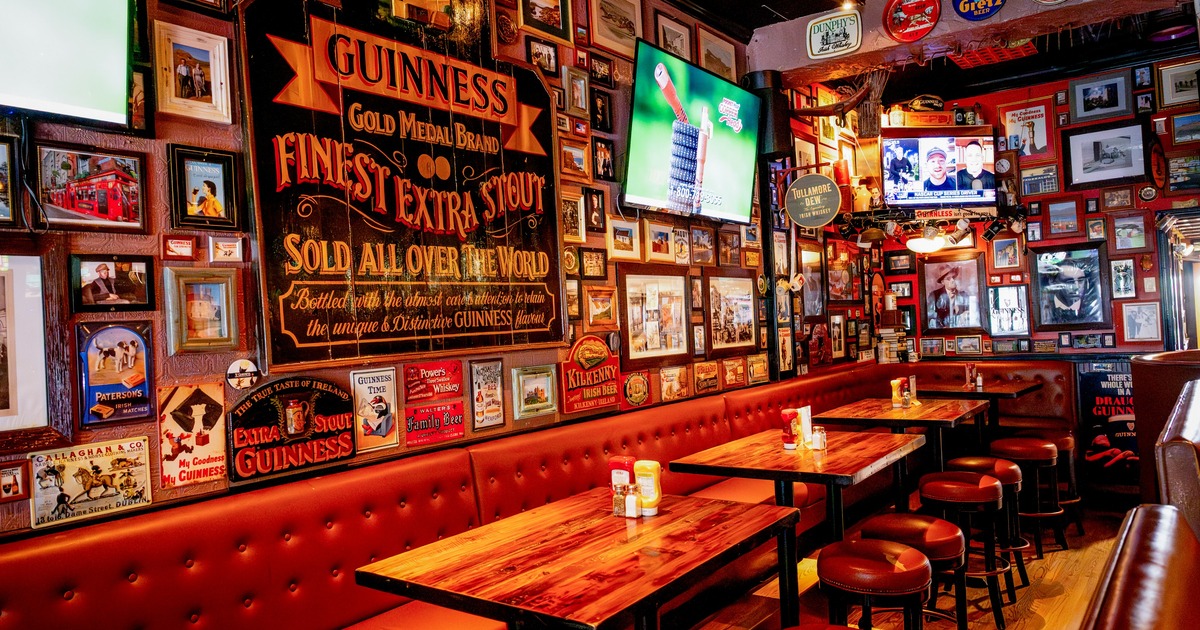 Interior, seating area with tables and leather benches, pub decor on the wall