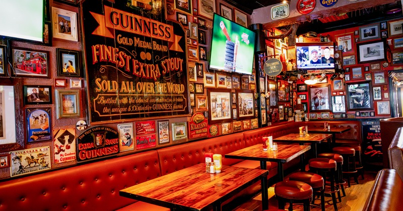 Interior, seating area with tables and leather benches, pub decor on the wall