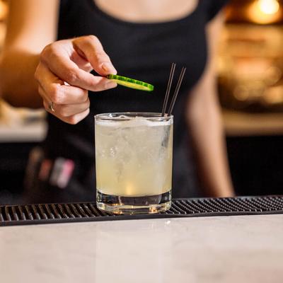 A bartender garnishing a cocktail.