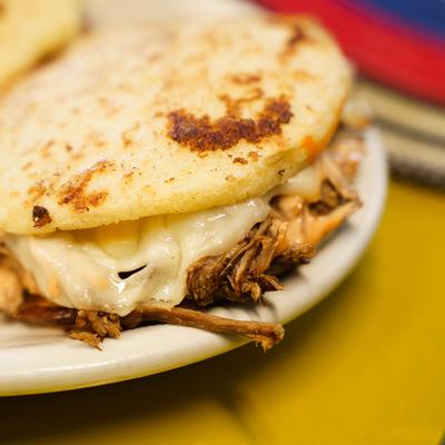Arepas, with shredded beef, creole sauce, cheese, corn and avocado.