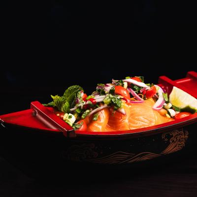 Salmon sashimi with scallions, chili, cherry tomatoes, and spicy lime sauce.