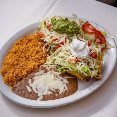 Taco salad, beans, and rice on a plate.
