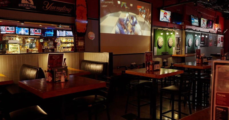 Interior, tall tables and bar chairs, booths, TVs and projection screen