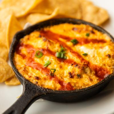 Buffalo Crab Dip in a Pan, chips behind.