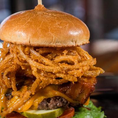 Pork Belly Burger with smoked cheddar, BBQ pork belly, and frizzled onions.