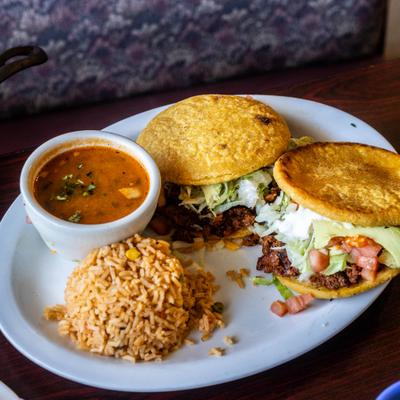 Gorditas stuffed with seasoned meat, lettuce and tomatoes, served with rice and beans.