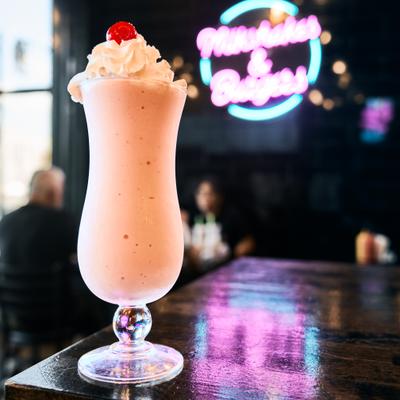 Strawberry Shake topped with whipped cream and a cherry.