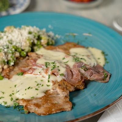 Scaloppine al Limone Thin sliced veal sautéed topped with slice of prosciutto lemon parsley cream sauce.