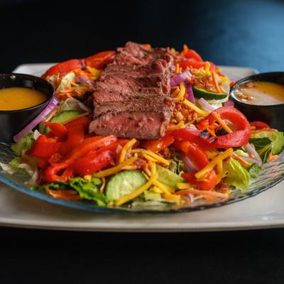 Steak Salad with roasted peppers, bacon, cheese crumbles and balsamic vinaigrette.
