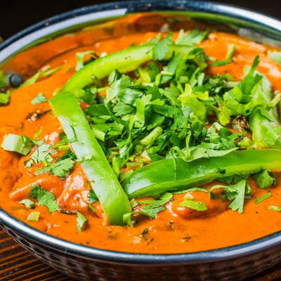Chicken Tikka Masala topped with fresh herbs and slices of pepper.