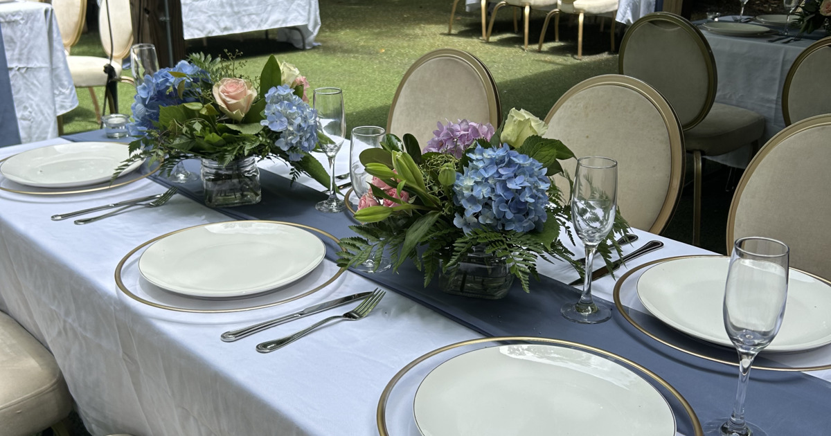 Table set with plates, glasses, sutlery and floral arrangements