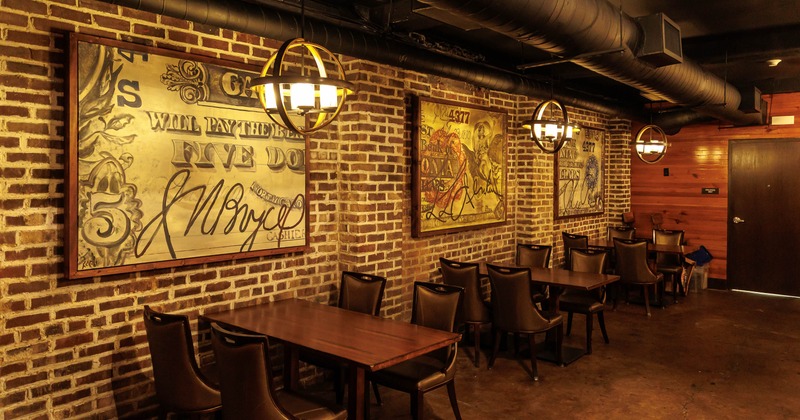 Warmly lit brick-walled dining room - leather chairs, wooden tables, vintage banknote artwork