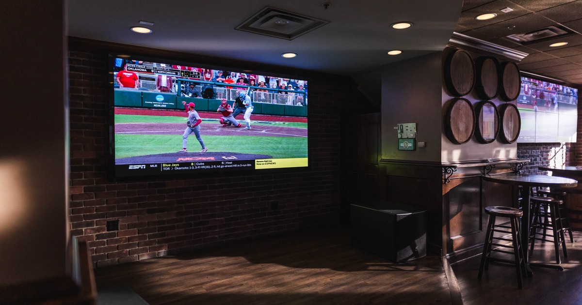 Interior featuring a large wall-mounted screen displaying a baseball game