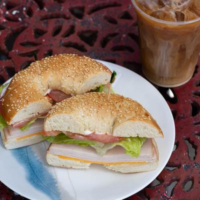 Ham sandwich on bagel paired with cold brew.