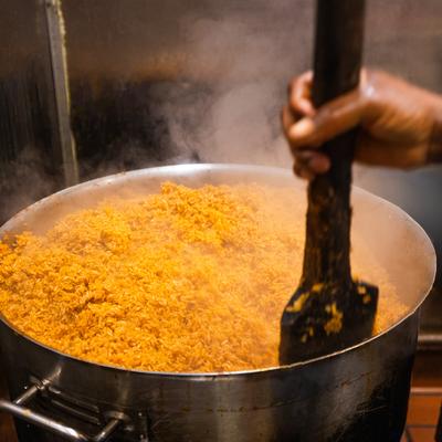 Nigerian jollof rice cooking in a large pot.