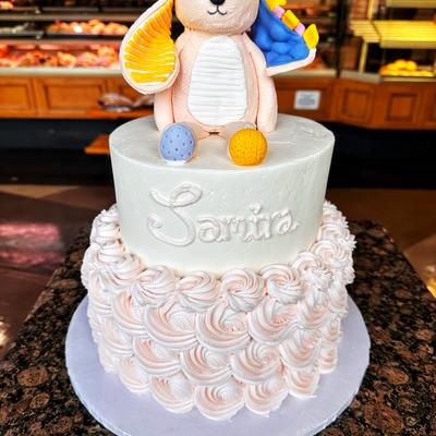 White cake with a edible bunny figurine on top.